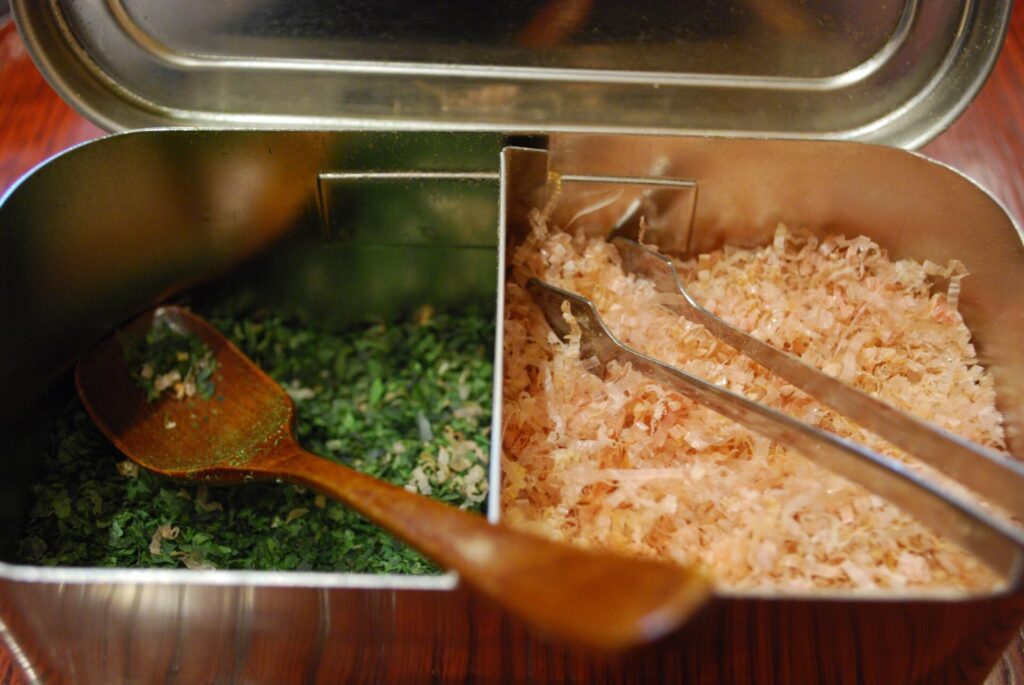 Pale pink shavings of dried smoked skipjack heaped loosely in a shallow wooden dish