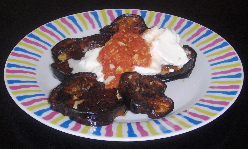 Golden fried eggplant cubes draining on a wire rack after coming out of the oil