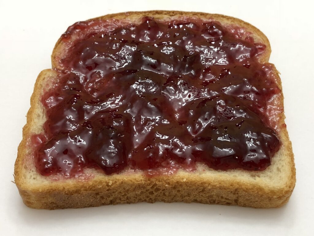 Slices of soft white sandwich bread with the crusts cut away on a wooden board