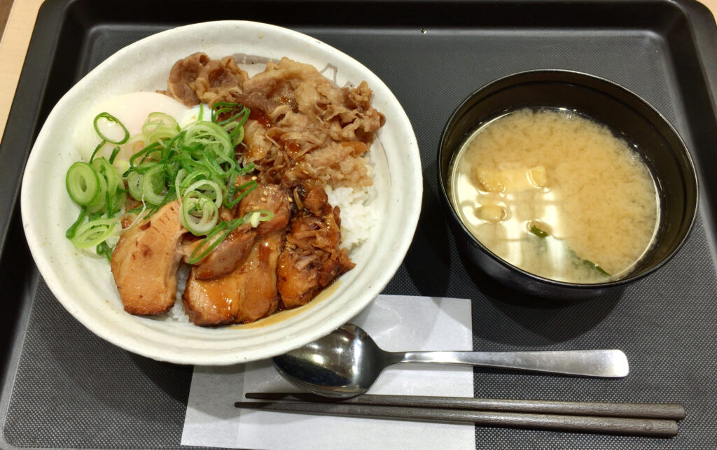 A bowl of pale pork stew with potato chunks and green chile strips in a clear broth