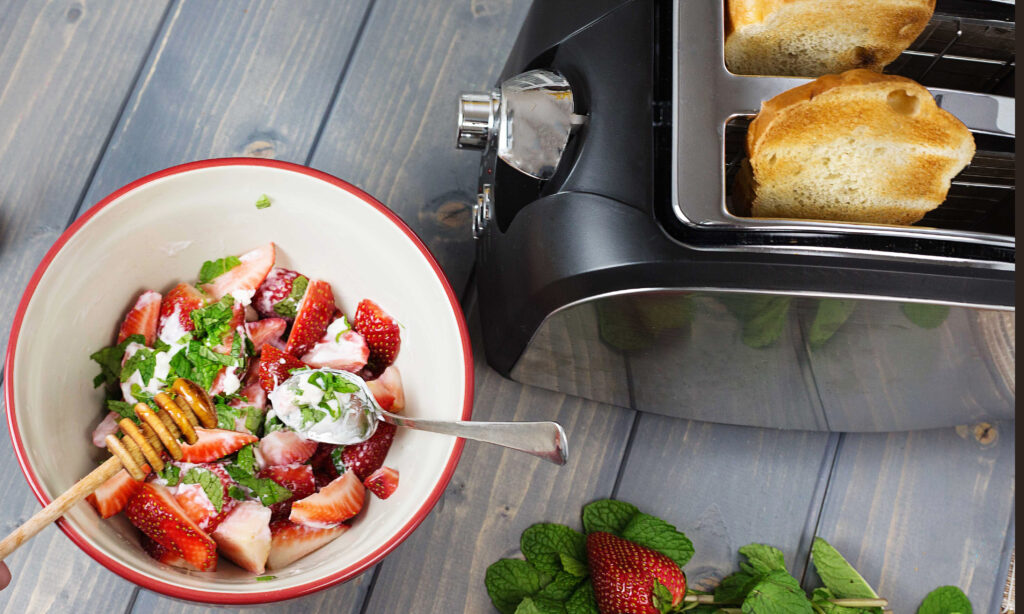 A dark bottle of balsamic vinegar beside a spoon holding a thick glossy pour