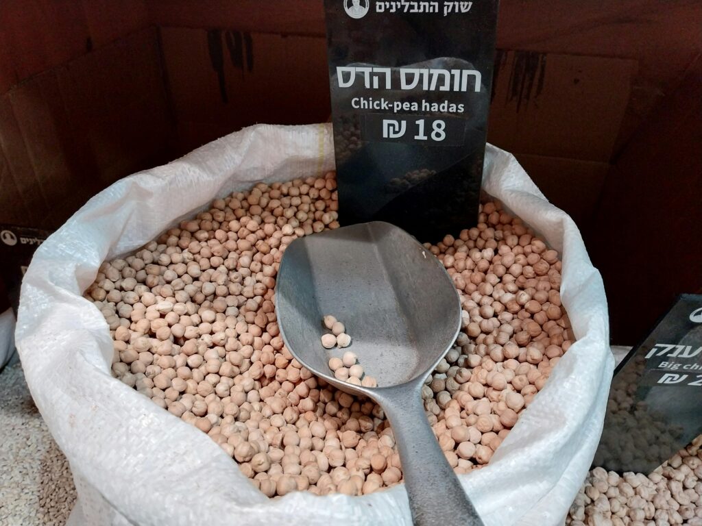 Dried short chickpea pasta shapes piled on a wooden board