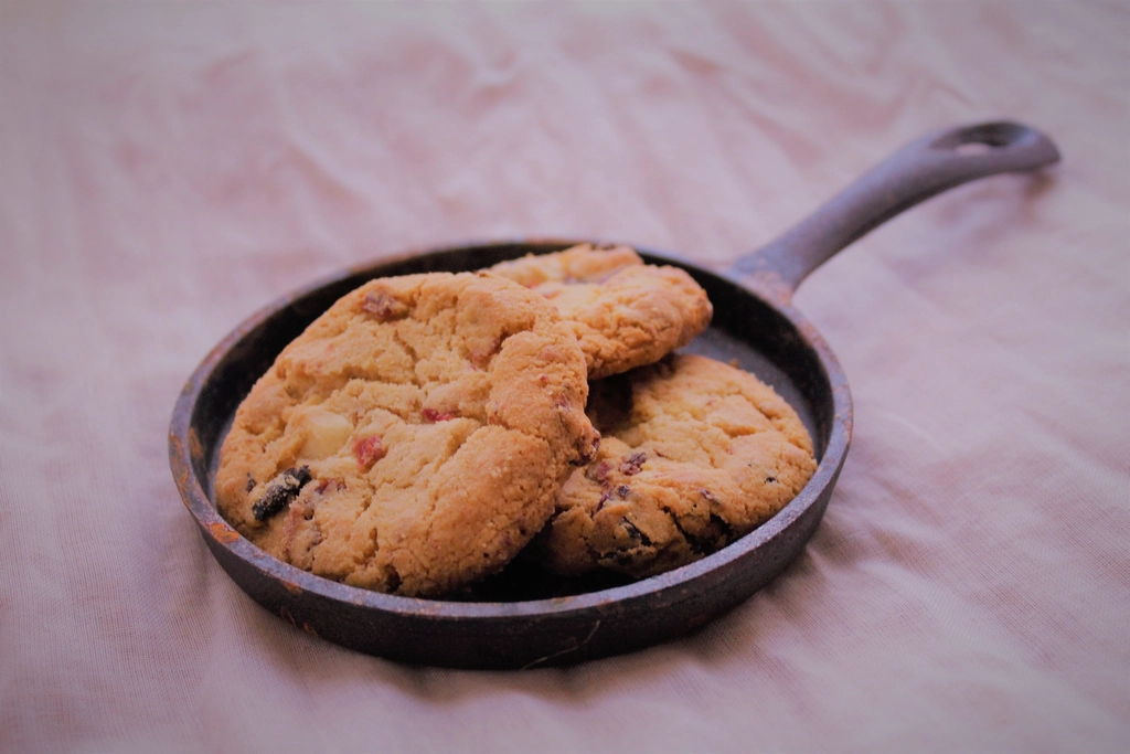 A thin round of dark spiced dough pressed into a seasoned cast iron pan