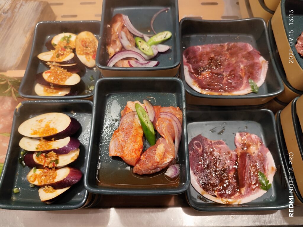 Thin strips of raw marbled beef arranged on a wooden cutting board beside a knife